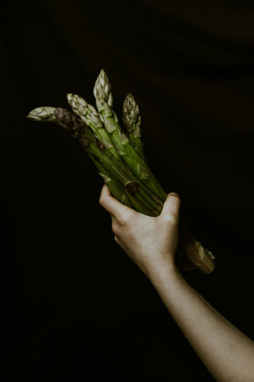 photo culinaire produit brut asperges dans la main clair obscur