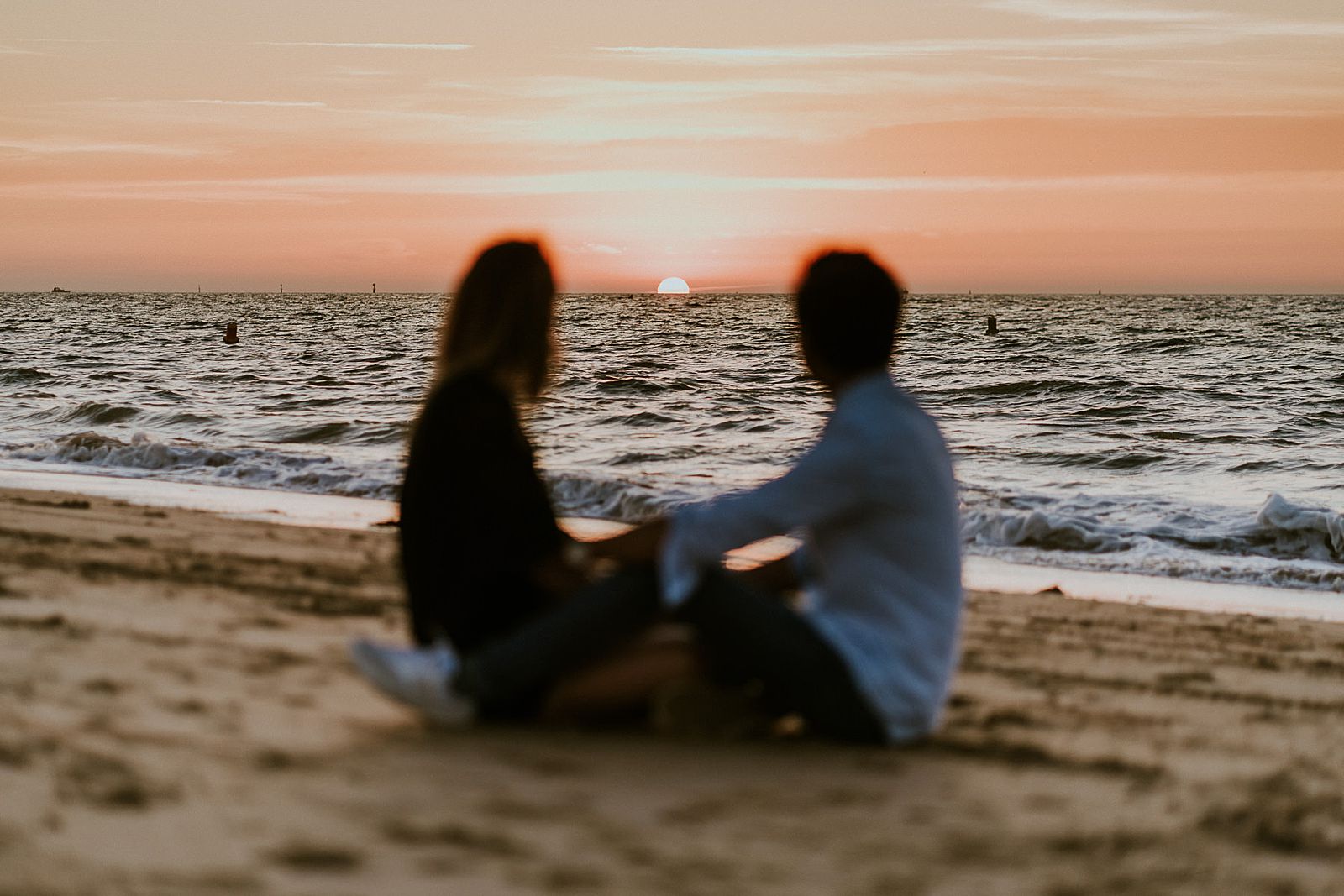 couple sur le sable au soleil couchant